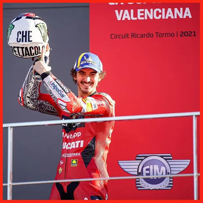 Francesco Bagnaia khoe chiếc nón Che Spettacolo 2004 trên podium chặng đua MotoGP Valencia 2021
